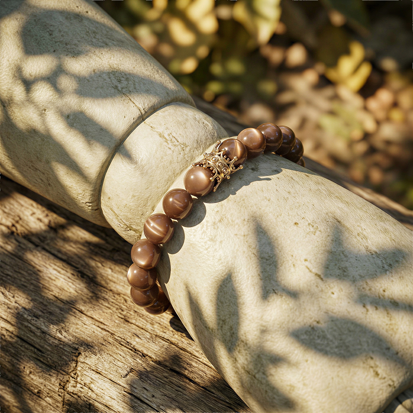 Chocolate moonstone 10mm bead stretch bracelet worn on wrist outdoors, warm daylight, relaxed natural setting