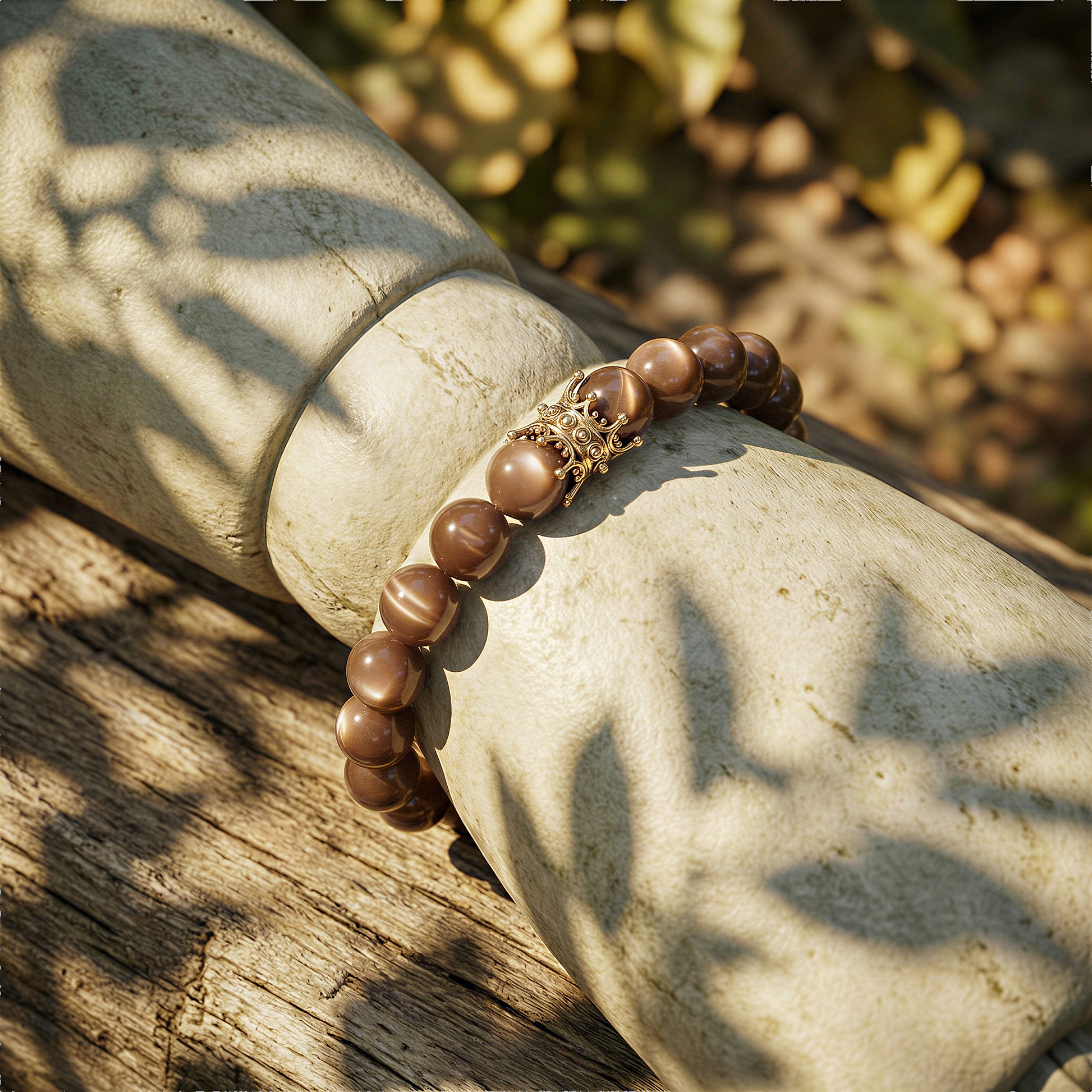 Chocolate moonstone 10mm bead stretch bracelet worn on wrist outdoors, warm daylight, relaxed natural setting