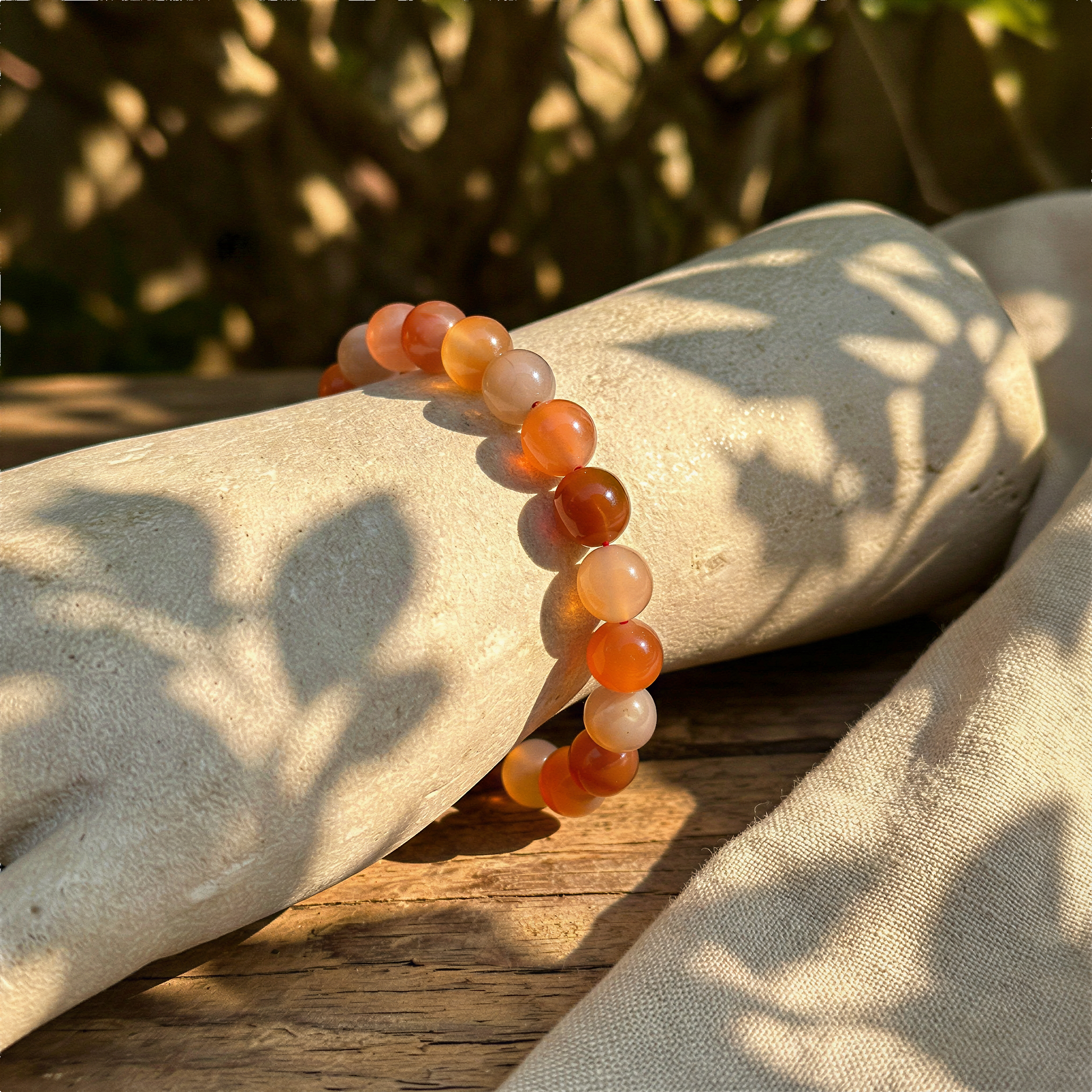 Mochi agate smooth round bracelet worn on wrist outdoors, bathed in warm daylight with natural, comforting surroundings