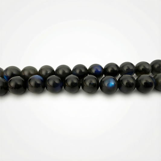 Smooth black labradorite round beads with subtle blue flashes, resting against a clean white background in soft, balanced studio light