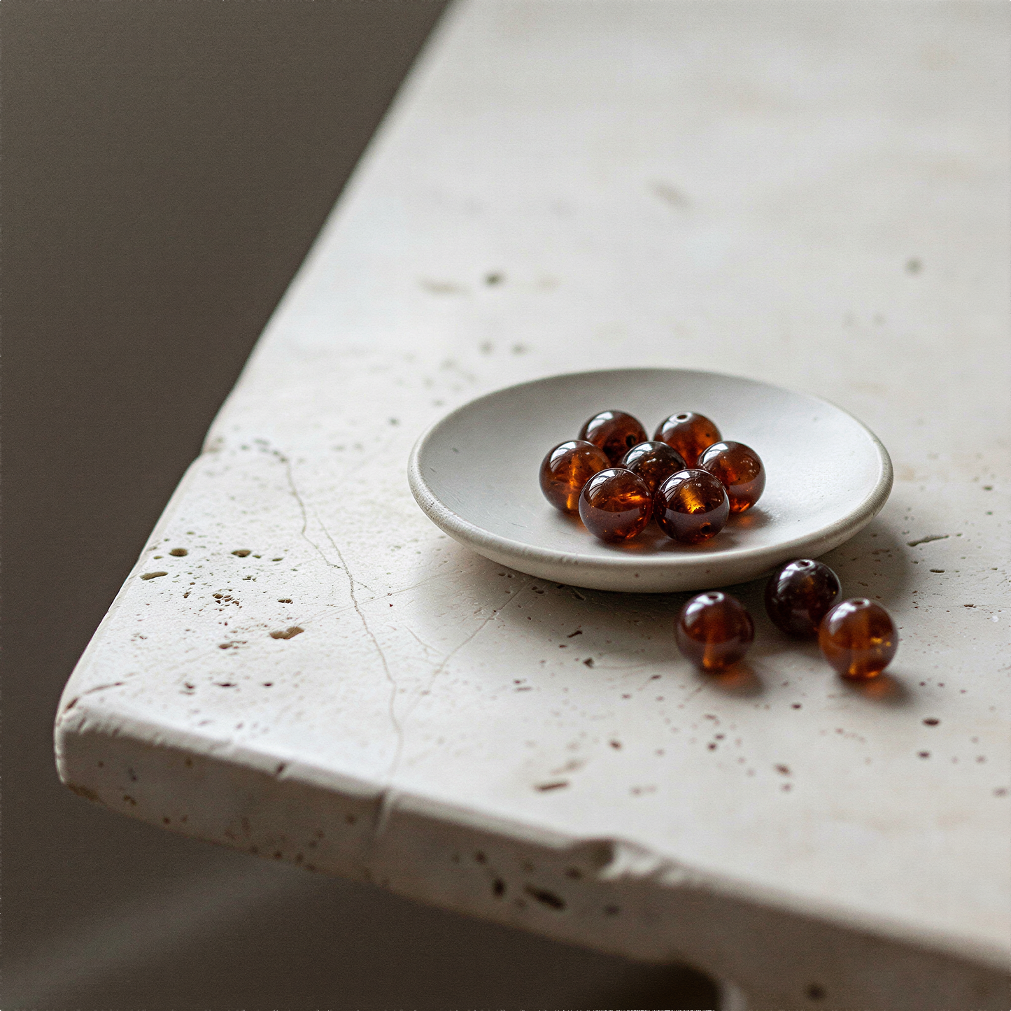 Single hessonite garnet bead resting on natural linen with soft daylight and muted earth tones