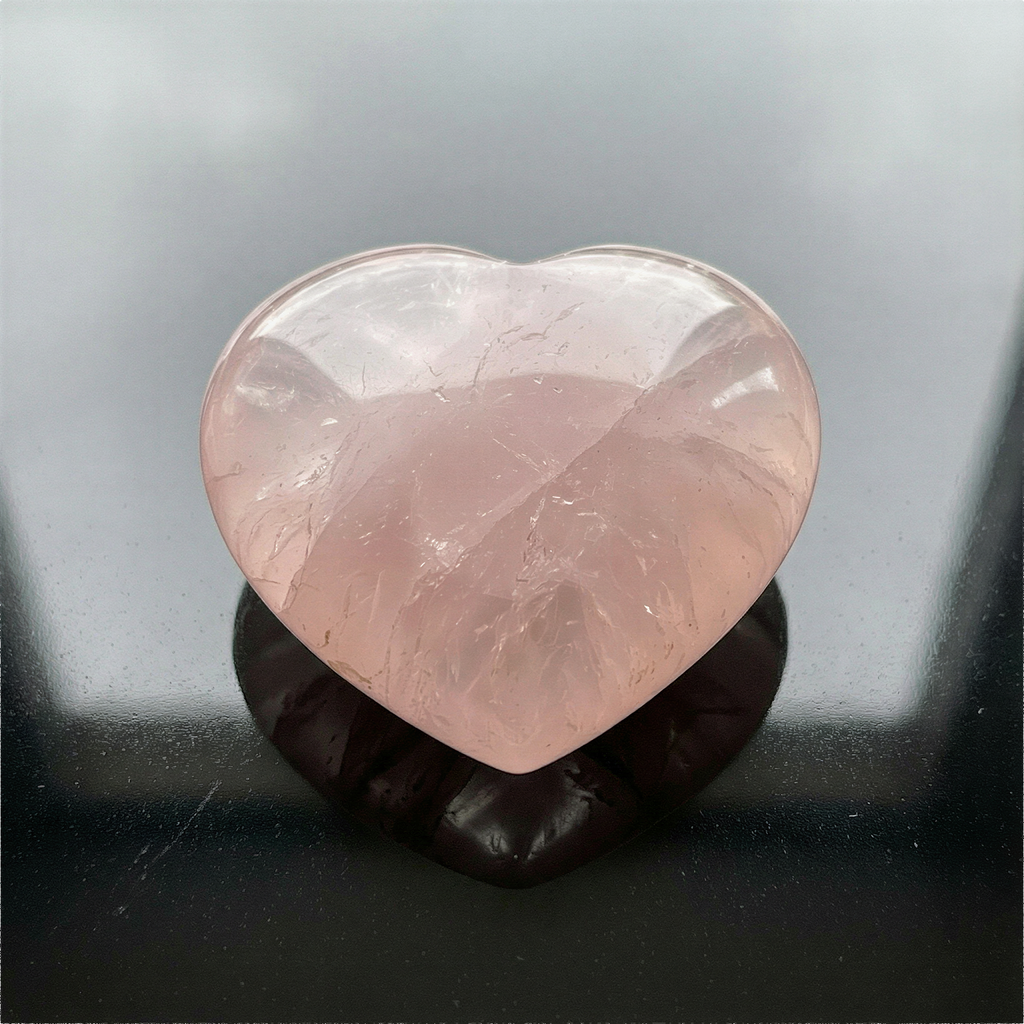 Puffed rose quartz heart palm stone photographed with refined clarity, soft lighting, and natural mineral texture preserved