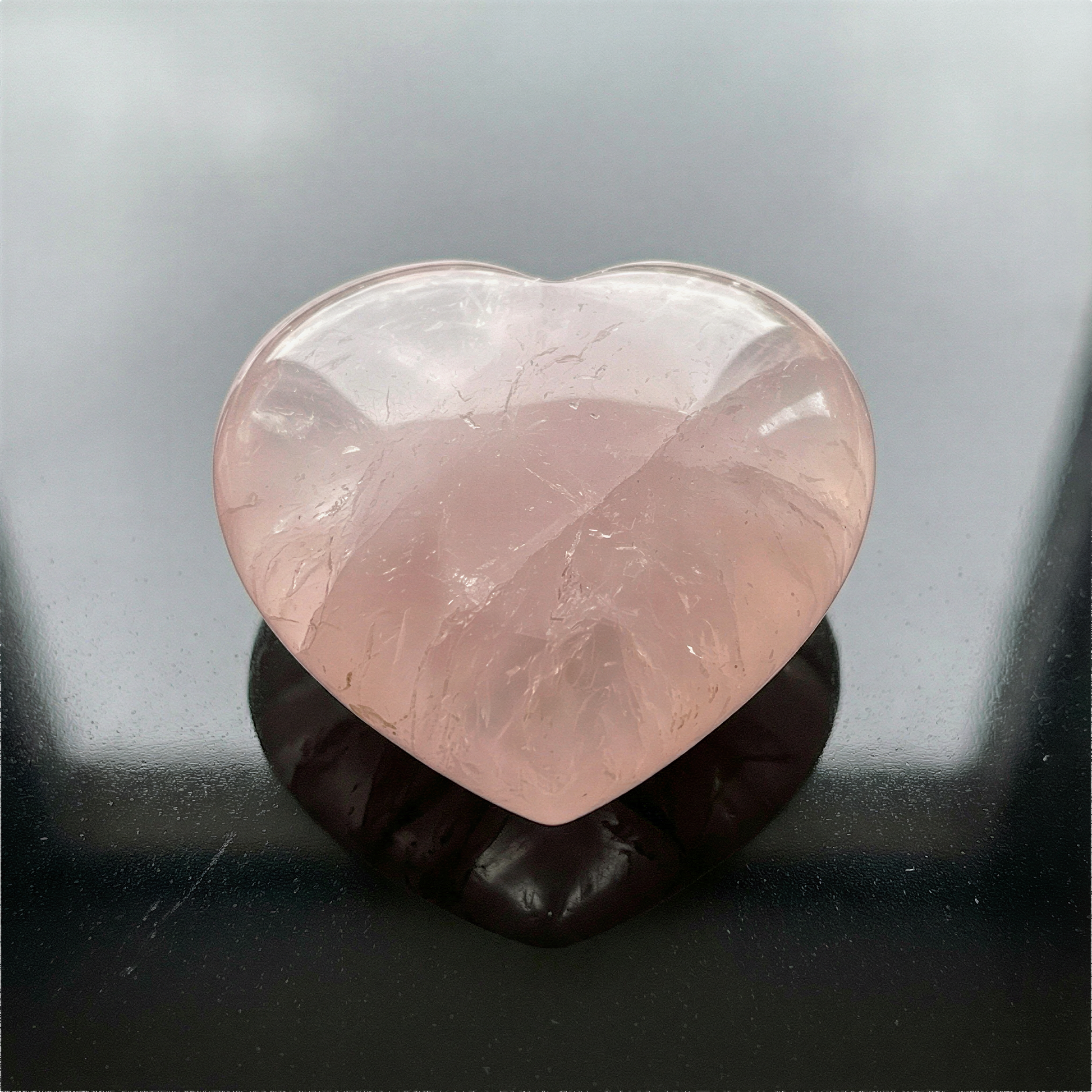 Puffed rose quartz heart palm stone photographed with refined clarity, soft lighting, and natural mineral texture preserved