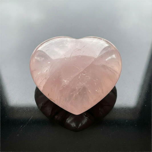 Puffed rose quartz heart palm stone photographed with refined clarity, soft lighting, and natural mineral texture preserved