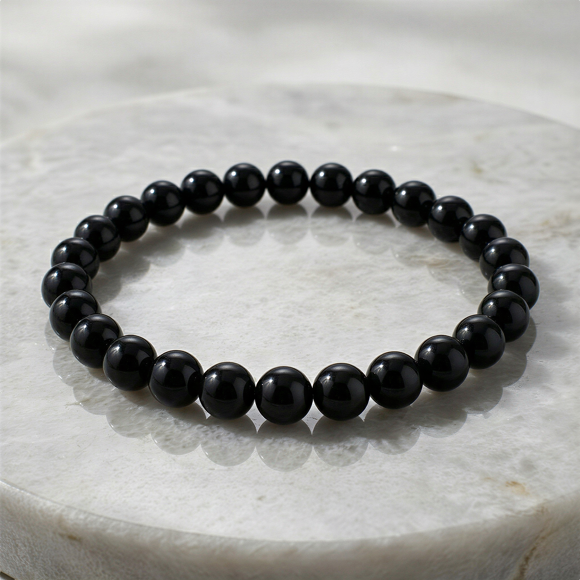 Black tourmaline smooth round bead bracelet subtly enhanced for clarity, rich tone, and refined, realistic finish
