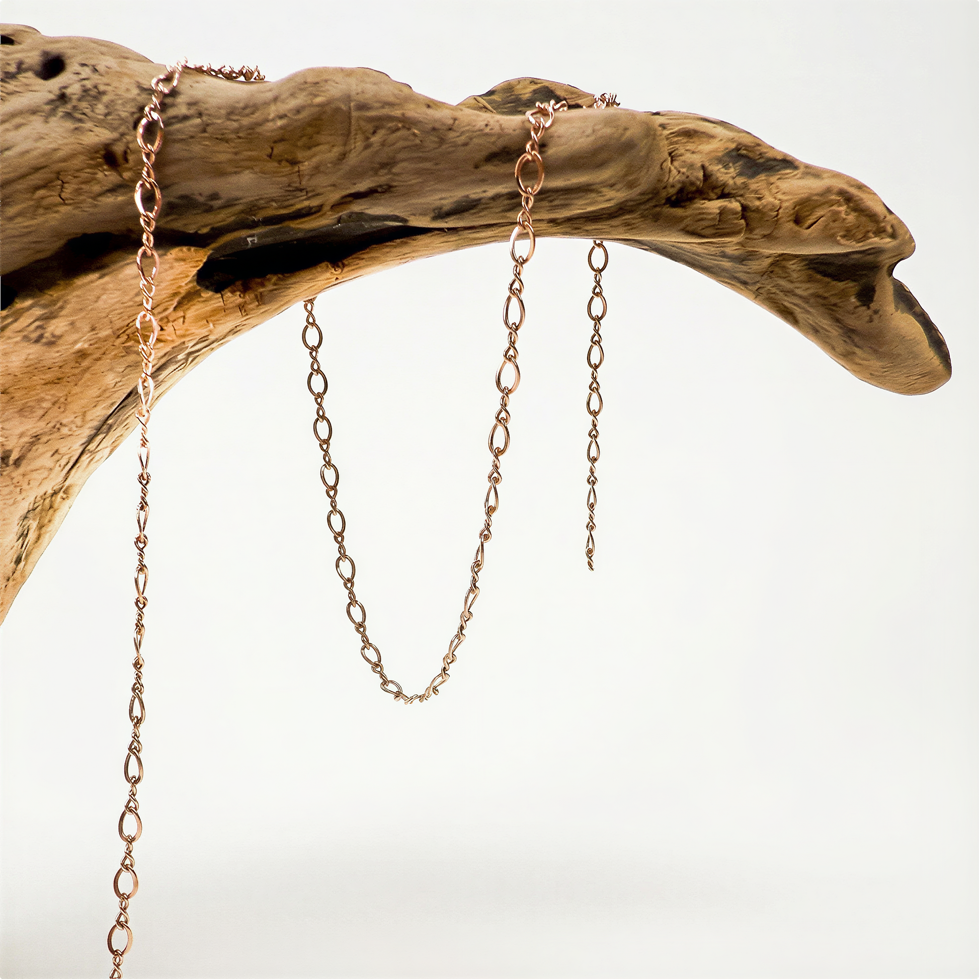 Rose gold filled figure eight chain displayed on neutral backdrop with soft lighting and refined clarity.