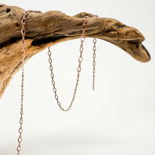 Rose gold filled figure eight chain displayed on neutral backdrop with soft lighting and refined clarity.