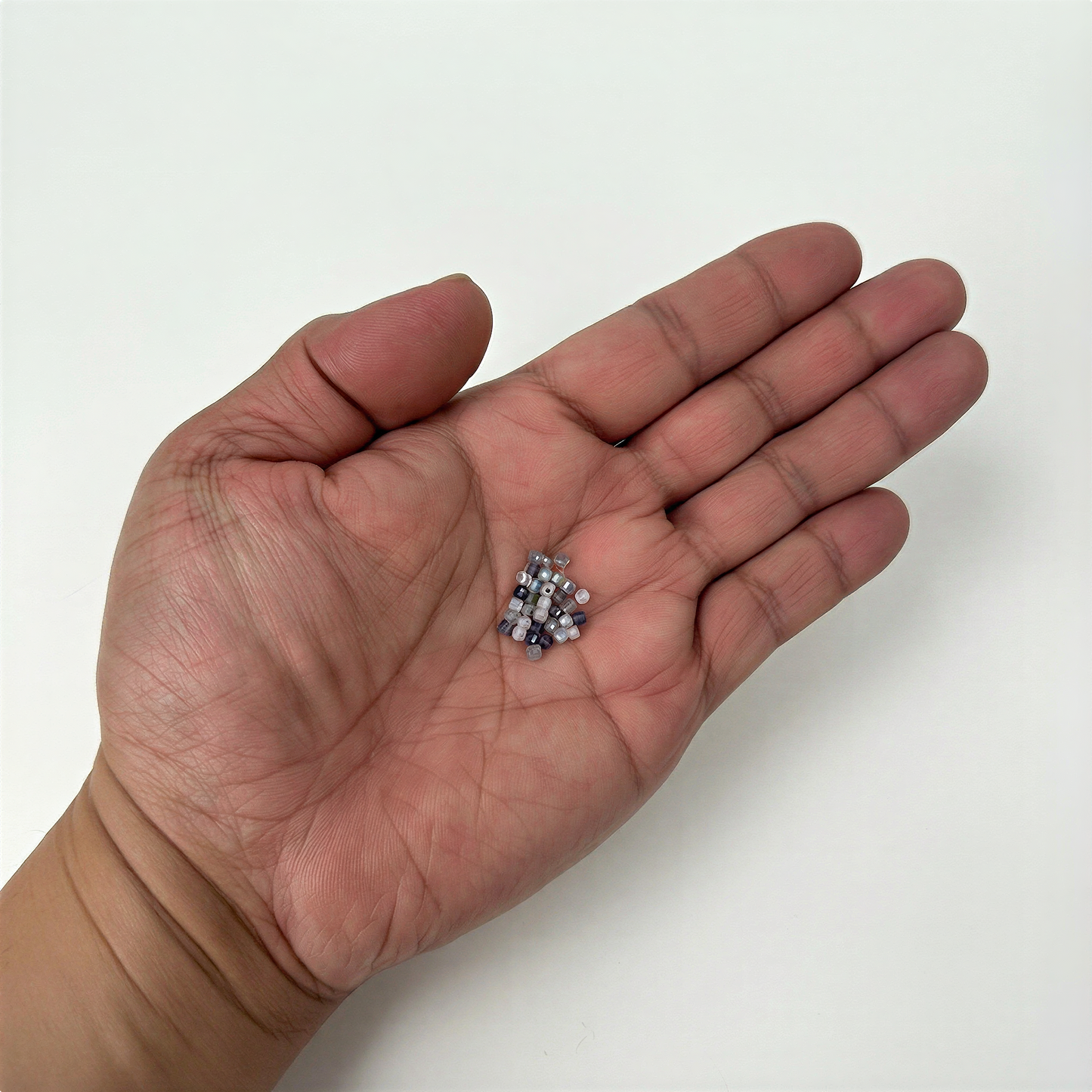 Faceted mixed gemstone cube beads arranged on soft neutral surface with balanced spacing and serene light