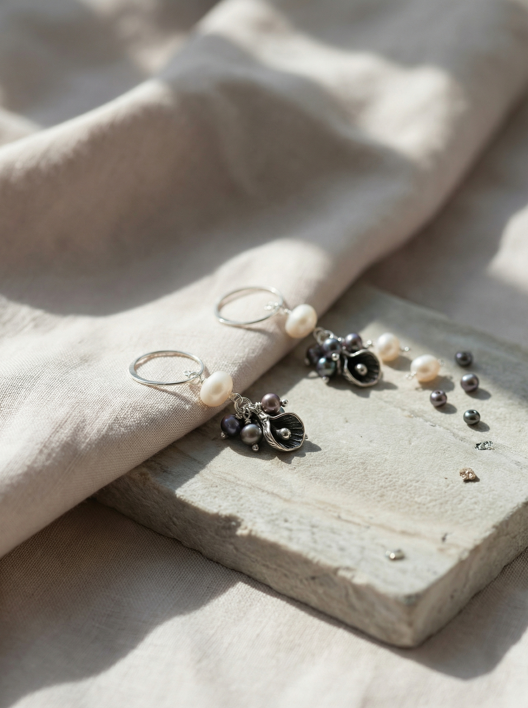 Sterling silver Calla Lily earrings on limestone and linen with soft morning light.