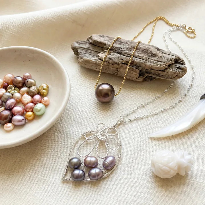 Colorful pearls and mother-of-pearl pieces arranged on warm linen